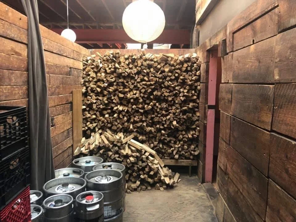 Firewood stacked in an indoor restaurant storage area